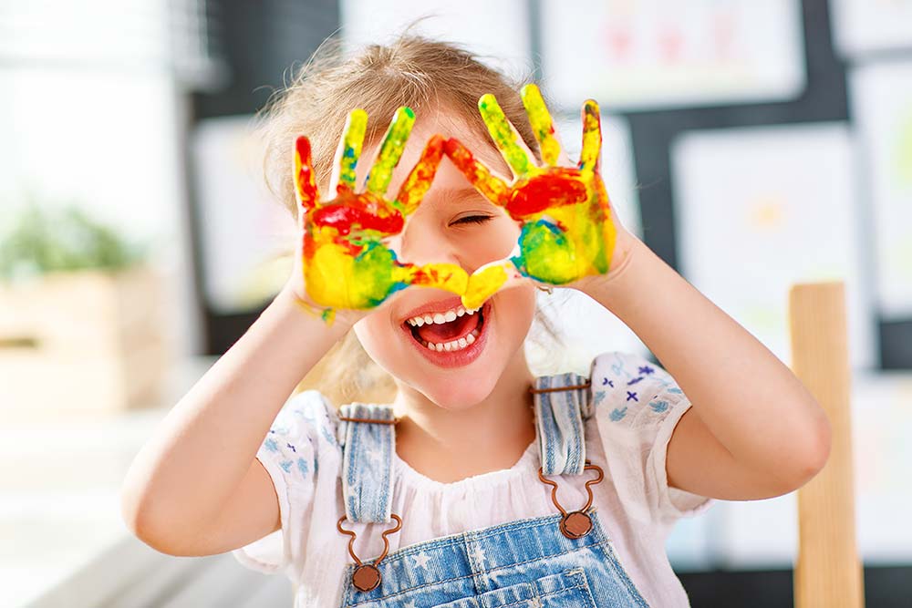toddler doing art with paint on her hands