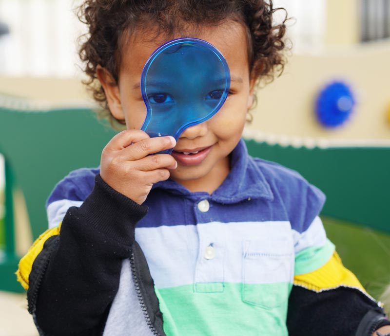 toddler using a magnifying glass
