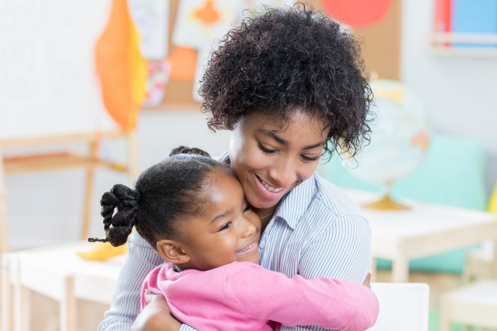 Early Education Franchise - Little girl hugs mother during day care interview